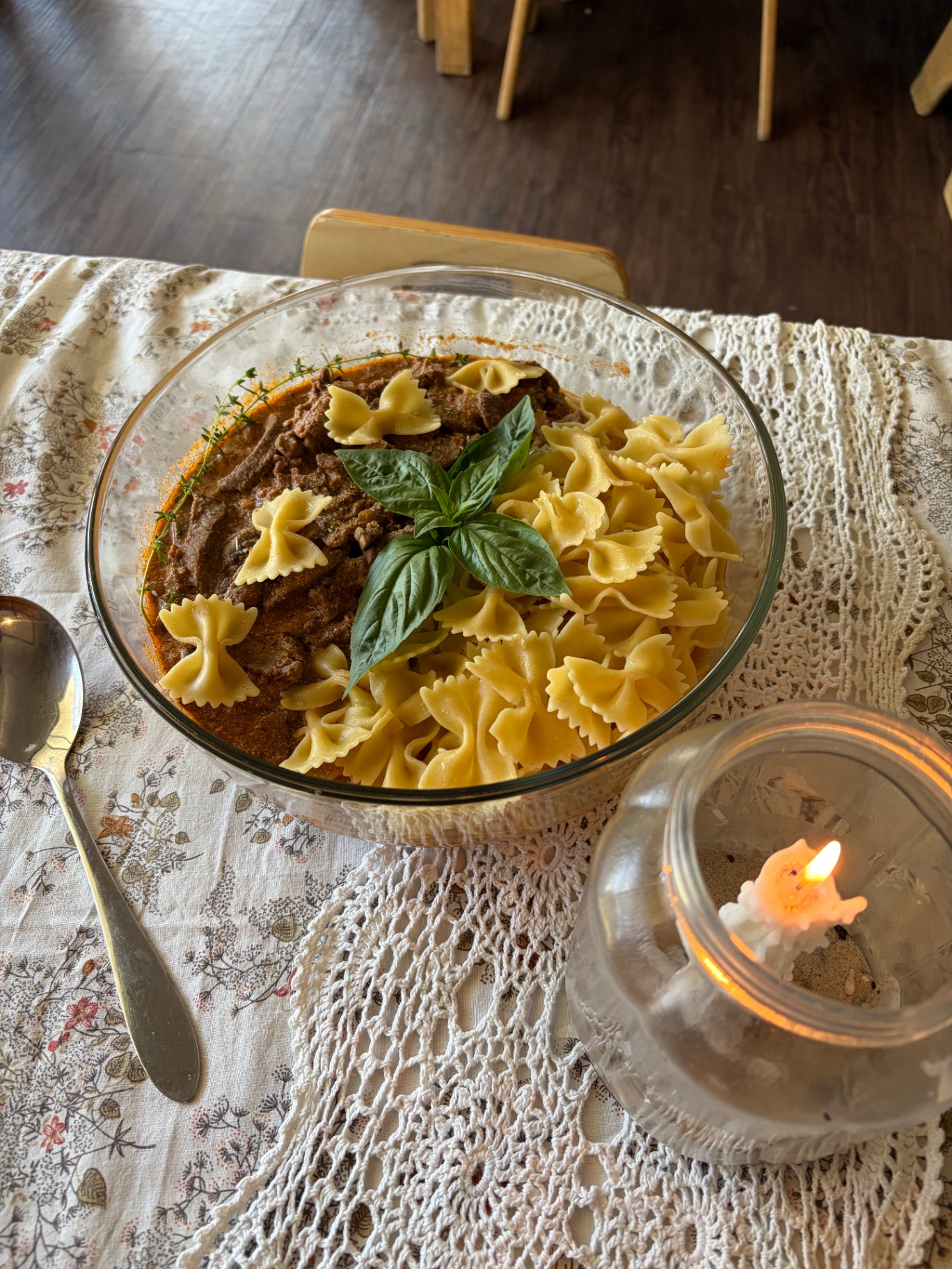 A shared family-style meal of pasta on a hand-crocheted tablecloth