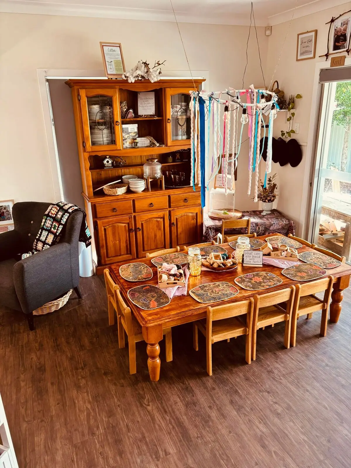 Indoor dining and dramatic play room with timber furniture and natural light at Natural Elements Merrimac